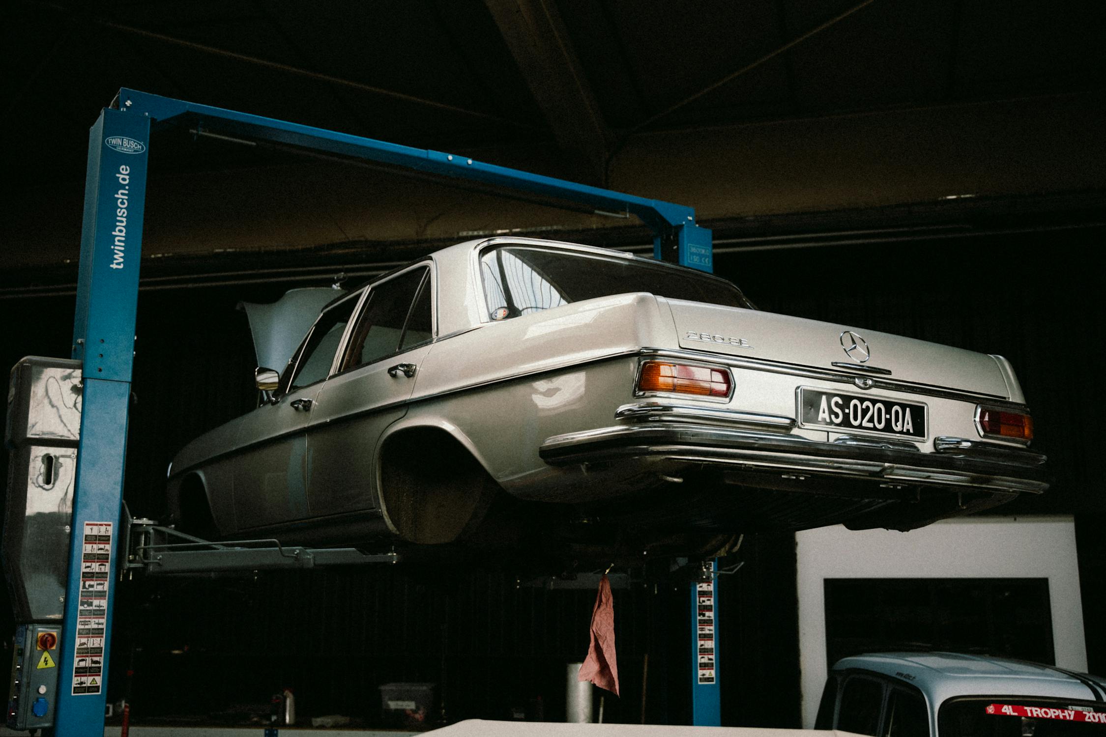 Classic Mercedes-Benz on lift at European auto repair shop